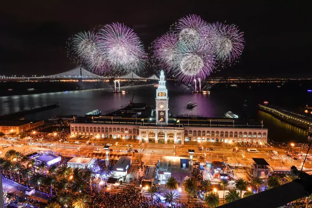 Fireworks explode over top of the Ferry Building, with the Bay Bridge in the background. 贝博体彩app，加利福尼亚州.